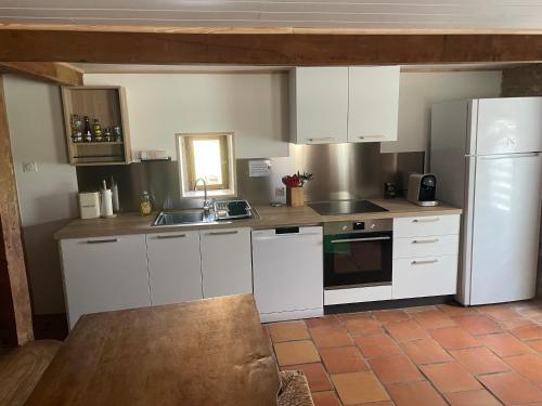 a kitchen with white cabinets and a sink at Le Clos des 4 Bastides in Saint-Eutrope-de-Born