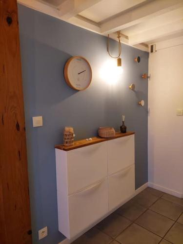 une chambre avec une horloge sur un mur bleu dans l'établissement Infinity View Bidart, à Bidart