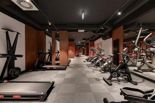 a gym with a row of exercise bikes and treadmills at Jacuzzi Mirror Suite by Downtown Apartments in Gdańsk