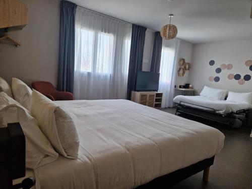 a hotel room with a large bed and a television at Beelodge Hotel Blois Centre in Blois