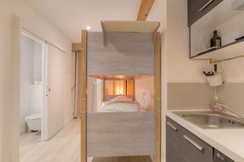 Cette petite chambre comprend une petite salle de bains avec un lit. dans l'établissement Spécial groupes Lyon - 10 personnes, à Lyon