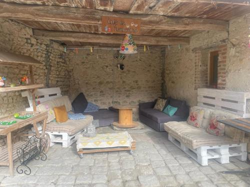 - un salon avec des canapés et des tables dans l'établissement La ferme du Baume, Loiret, à Beaune-la-Rolande