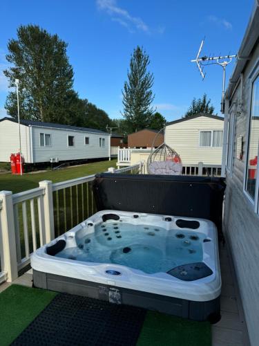 a hot tub sitting on the back of a porch at Hot tub retreat at Tattershall Lakes in Tattershall