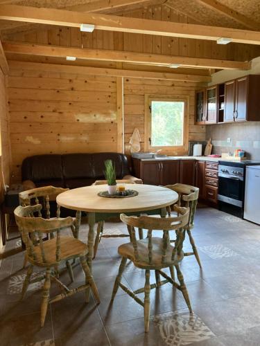 a kitchen and dining room with a table and chairs at Gruzanski Raj in Knić