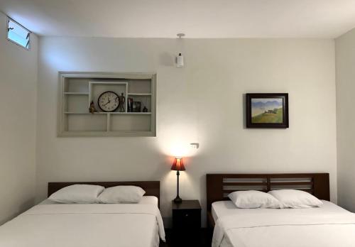 two beds in a room with a clock on the wall at Fam Friendly-Center Old Quater-Super Location in Hanoi