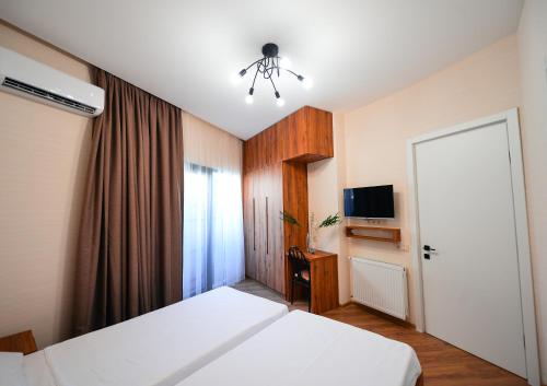 a hotel room with a bed and a television at Labu Hotel in Tbilisi City