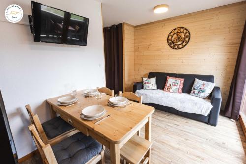 un salon avec une table et un canapé dans l'établissement Appartement - Label Dévoluy 4 diamants, à Saint-Étienne-en-Dévoluy