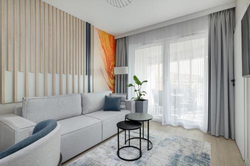 a living room with a couch and a table at Apartament Baltic Waves Basen Siłownia Sauna by Rent like home in Międzyzdroje