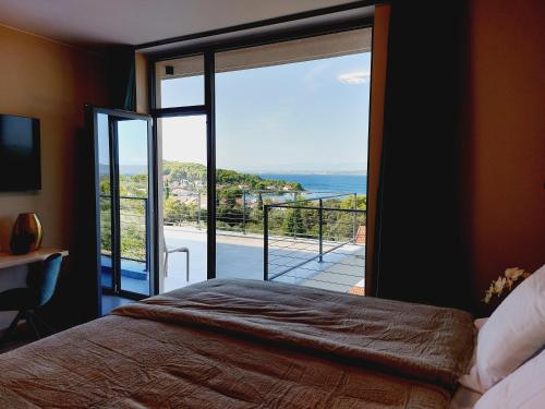 een slaapkamer met een grote glazen deur naar een balkon bij Villa Supreme Pašman Zadar in Ždrelac