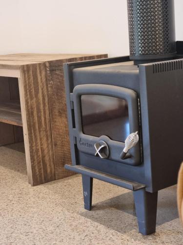 a wood stove with a shell on it next to a table at The Stables Nug Nug Ranch in Buffalo River