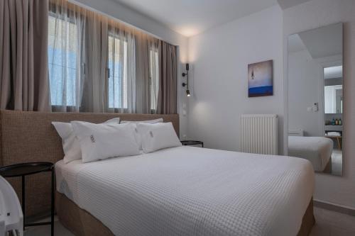 a bedroom with a large bed with white sheets at Anima Residence in Nea Roda