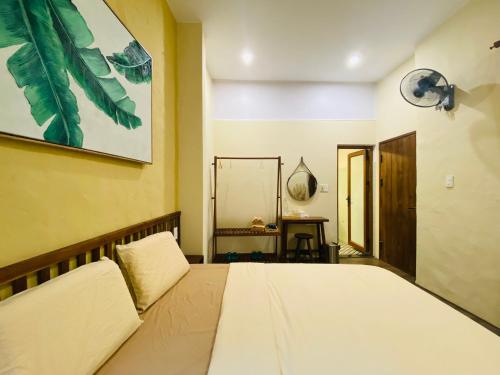 a bedroom with a bed and a painting on the wall at PIA homestay - Tours & Motorbike rentals - Cao Bằng in Cao Bằng