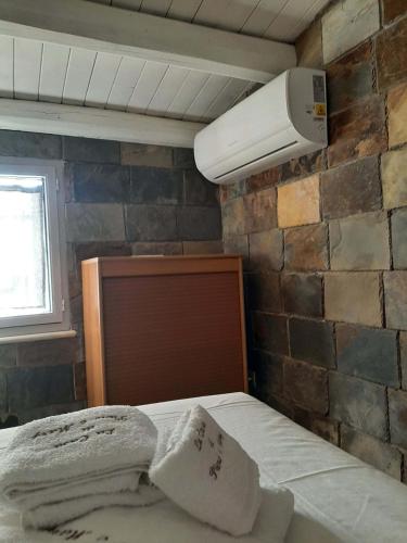 a bed with two pillows and a light on a brick wall at La Casa Di Piero e Mary in Brucoli