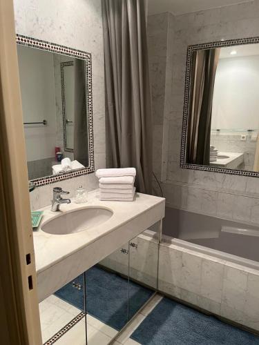 une salle de bain avec un lavabo, un miroir et une baignoire dans l'établissement Aufenthalt im Herzen von Cannes, à Cannes