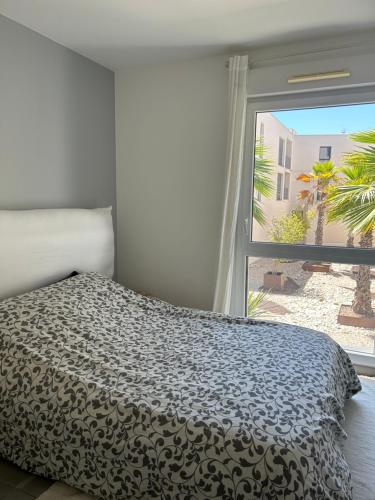 une chambre avec un lit et une grande fenêtre dans l'établissement Maison avec Jardin, à Baillargues