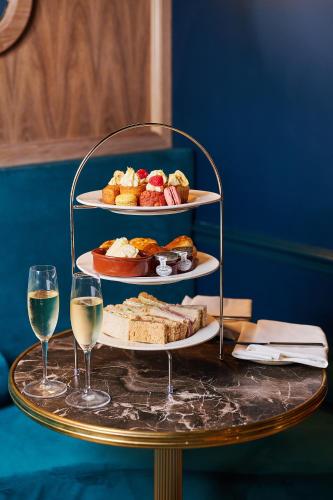 a table with two plates of food and two glasses of wine at Milford Hall Salisbury in Salisbury