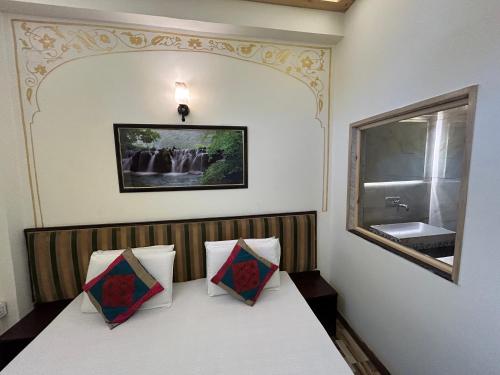 a room with a bench with two pillows on it at Max Guest House in Agra