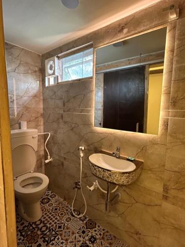 a bathroom with a sink and a toilet at Max Guest House in Agra