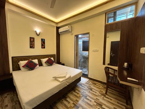 a bedroom with a bed and a window and a television at Max Guest House in Agra