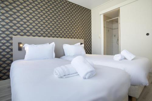 two beds with white pillows in a bedroom at GAB HOUSE - Lyon Bron - Eurexpo City Living Stay in Bron