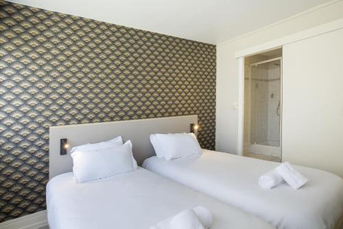 two beds with white pillows in a bedroom at GAB HOUSE - Lyon Bron - Eurexpo City Living Stay in Bron