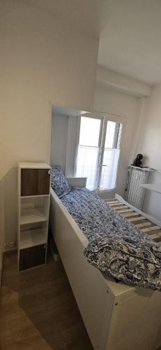 une petite chambre avec un lit et une fenêtre dans l'établissement Studio de 11m centre du havre, au Havre