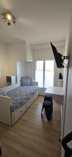 - une chambre avec un lit et un bureau avec un parasol dans l'établissement Studio de 11m centre du havre, au Havre