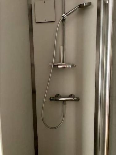 une douche avec un tuyau raccordé à un réfrigérateur dans l'établissement Studio de 11m centre du havre, au Havre