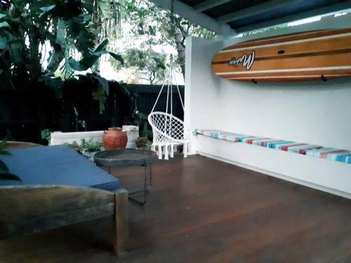 a room with a surfboard hanging on a wall at Trendy Beach Studio in Lennox Head