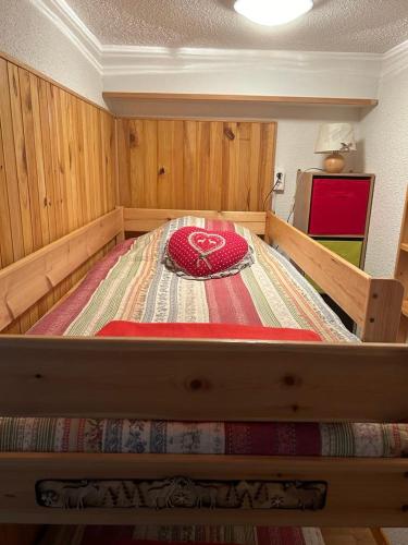un grand lit dans une chambre aux murs en bois dans l'établissement L'étoile des neiges Studio confort pour 4 personnes, à Montclar