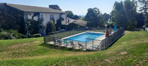 une clôture autour d'une piscine dans une cour dans l'établissement The Originals City, Hôtel La Siesta, Annonay Est, à Davézieux