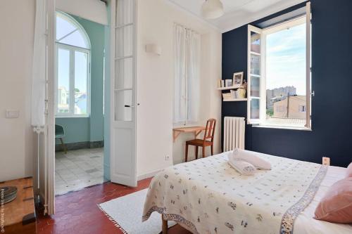 une chambre avec un lit, un bureau et une fenêtre dans l'établissement Villa Emma au coeur de Malmousque, à Marseille