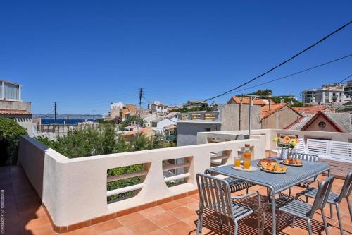 un patio avec une table et des chaises sur un balcon dans l'établissement Villa Emma au coeur de Malmousque, à Marseille