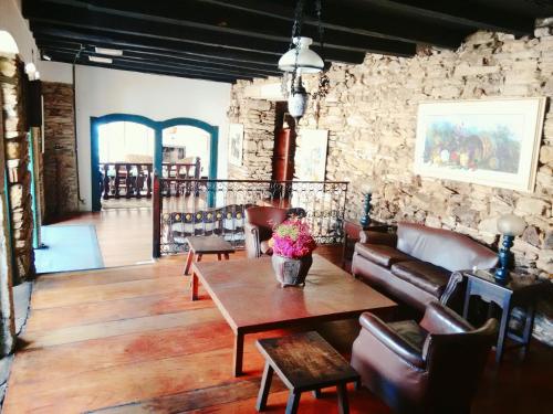 a living room with a table and a stone wall at Hotel Luxor in Ouro Preto