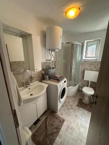 a bathroom with a sink and a washing machine at Apartment MIP in Tisno