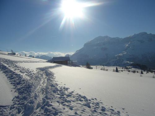 a snow covered slope with the sun in the sky at Residence Vajolet San Cassiano in San Cassiano