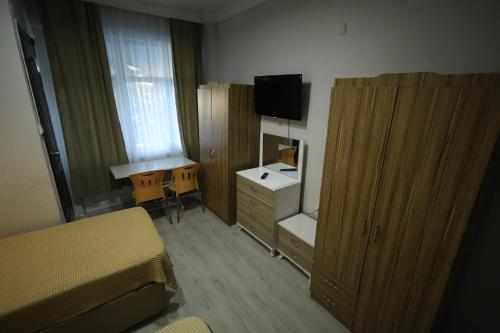 a bedroom with a bed and a desk and a television at Hotel Cappa in Ürgüp