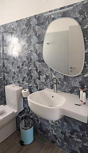 a bathroom with a sink and a mirror and a toilet at Dendrinos studio in Galissas