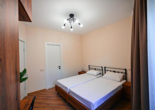 a bedroom with a bed and a chandelier at Labu Hotel in Tbilisi City