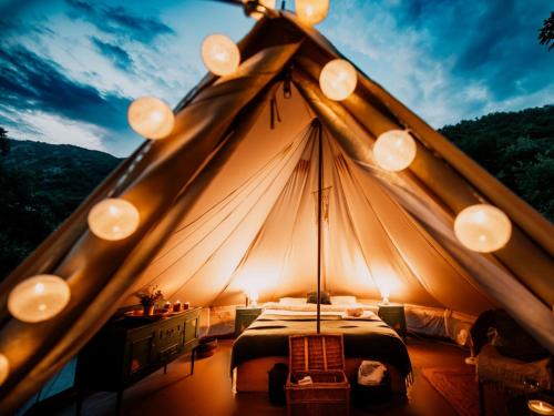 a tent with a bed and lights in it at Hoopoe Glamping in Virpazar