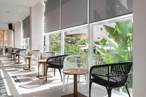 a row of tables and chairs in a room with windows at Eurosalou & Spa in Salou