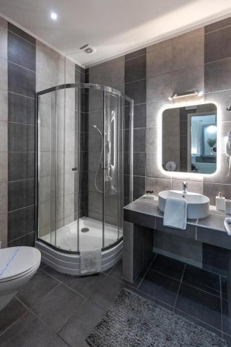 a bathroom with a shower and a sink and a toilet at Royal Apartments Hotel Kecskemét in Kecskemét