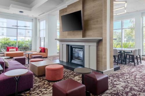 a living room with a fireplace and a tv at Hilton Garden Inn Sarasota-Bradenton Airport in Sarasota