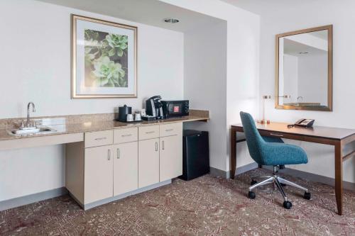 a room with a desk and a chair and a sink at Hilton Garden Inn Sarasota-Bradenton Airport in Sarasota
