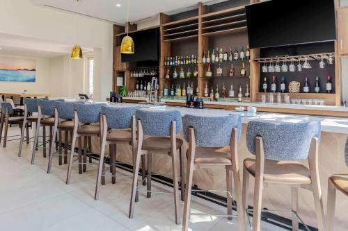 a bar with a row of chairs in a restaurant at Hilton Garden Inn Sarasota-Bradenton Airport in Sarasota