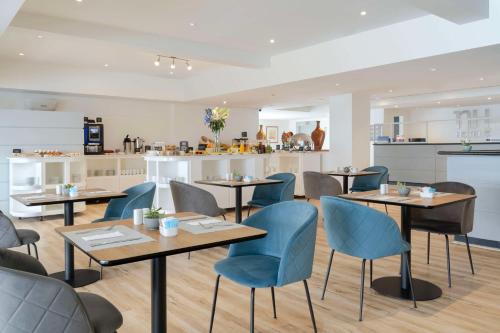 a restaurant with tables and chairs and a kitchen at NH Iquique Costa in Iquique