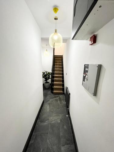 a hallway with a staircase and a light fixture at Fabulous 3 Bed Apartment - Near Excel - Sleeps 6 - 8 in London