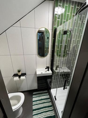 a bathroom with a toilet and a sink and a mirror at Fabulous 3 Bed Apartment - Near Excel - Sleeps 6 - 8 in London
