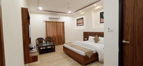 a bedroom with a bed and a table in a room at Sun Stone Hotel & Club - Jawai in Sheoganj