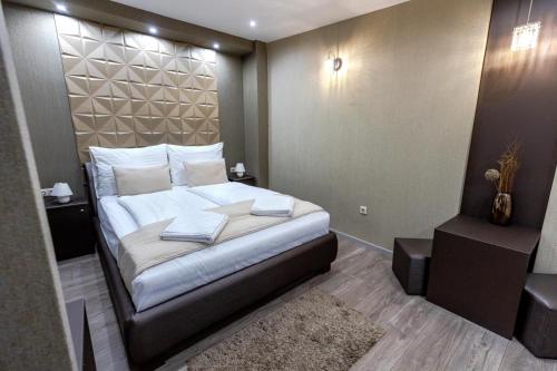 a bedroom with a bed with white pillows on it at Royal Apartments Hotel Kecskemét in Kecskemét